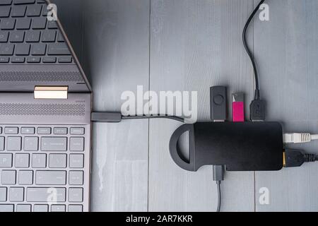 USB-Adapter Typ C oder Hub, der mit verschiedenen Zubehörteilen an den Laptop angeschlossen ist - Pendreifen, hdmi, ethernet, Kabel. Flacher Lay Draufsicht. Stockfoto