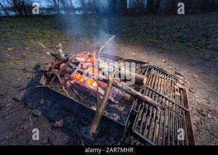 Lagerfeuer draußen in Dänemark auf dem Land. Brennende Protokolle auf dem Grill Stockfoto
