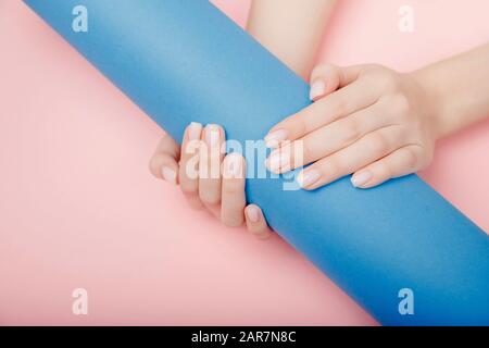 Modische modische Nagelmaniküre Frau übergibt sich auf pinkfarbenem und blauem Hintergrund, Draufsicht Stockfoto