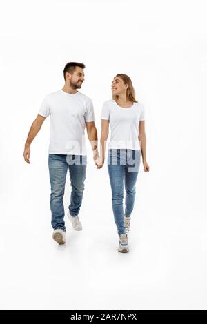 In voller Länge Porträt des glücklichen Paares im casual Outfit gemeinsam vorwärts gehen auf weißem Hintergrund Stockfoto
