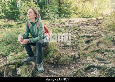 Weibliche Wanderer, die sich im Wald ausruhen und betrachten, machen eine Pause vom Wandern im Freien in den Wäldern Stockfoto