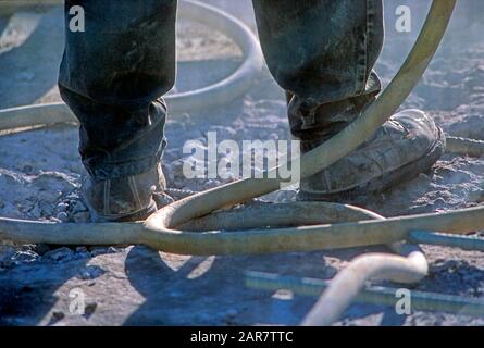 Stiefel des Bauarbeiters bei Verwendung eines Jackhammer Stockfoto