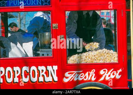 Vintage Popcorn Cart und Händler, die Schaufeln von Popcorn verkaufen Stockfoto