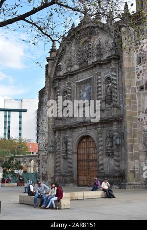 Die Menschen ruhen auf Bänken vor dem Templo de San Francisco de Asis, einer neoklassizistischen Kirche Guadalajaras Jardin de San Francisco. Stockfoto