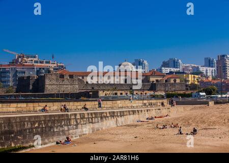 Porto, PORTUGAL - MAI 2018: Touristen und Einheimische, die einen schönen frühen Frühlingstag in Praia das Pastoras und der Festung von Sao Joao da Foz genießen Stockfoto