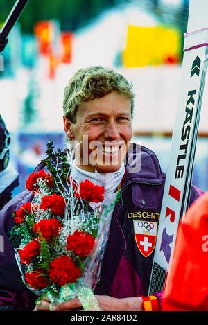 Pirmin Zürbriggen aus der Schweiz (C) gewinnt bei den Olympischen Winterspielen 1988 die Goldmedaille in der Abfahrt. Stockfoto