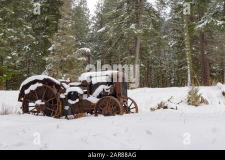 Ein alter Traktor vom Typ Mc Cormick-Deering von 1929 10-20 im Schnee, entlang des Überschwemmungsgebiets Rock Creek südöstlich von Clinton im Missoula County, Montana Stockfoto