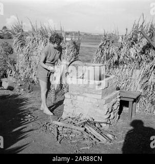 Niederländische Antillen und Suriname zur Zeit des königlichen Besuchs von Königin Juliana und Prinz Bernhard im Jahre 1955 Strohhalm an einem improvisierten Kochplatz am Ufer der Fuikbucht Datum: Oktober 1955 Ort: Curaçao Schlüsselwörter: Kochen, Frauen Stockfoto