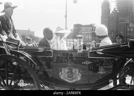 Staatsbesuch von Präsident Félix Houphouët-Boigny von Côte d'Ivoire in den Niederlanden Reittour vom Hauptbahnhof zum Palast am Staudamm: calèche mit Prinzessin Beatrix, Félix Houphouët-Boigny und Königin Juliana Datum: 2. Juni 1970 Ort: Amsterdam, Noord-Holland Schlüsselwörter: Kutschen, Autofahrten, Staatsbesuche persönlicher Name: Beatrix, Prinzessin, Houphouët-Boigny, Félix, Juliana, Name der Queen Institution: Palast am Staudamm Stockfoto