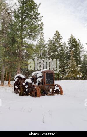 Ein alter Traktor vom Typ Mc Cormick-Deering von 1929 10-20 im Schnee, entlang des Überschwemmungsgebiets Rock Creek südöstlich von Clinton im Missoula County, Montana Stockfoto