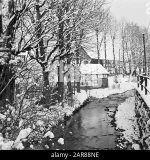 Rothaargebergte der Odeborn mit Fachwerk in Girkhausen im Winter Datum: Undatierter Standort: Deutschland, Girkhausen, Nordrhein-Westfalen, Westdeutschland Schlagwörter: Bäche, Dorfstatuen, Schnee, Winter Stockfoto