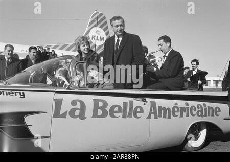 Robert Dhery, der französische Regisseur des Films La Belle Americaine mit Frau und Schauspielerin Colette Brosset am Flughafen Schiphol (+ das ursprüngliche Auto der Belle Americaine, auf dem der Text der My Fair Lady aufgebrochen ist] Datum: 22. Februar 1962 Ort: Schiphol, Zuid-Holland Schlüsselwörter: Schauspielerinnen, Autos, Film, Filmregisseure, Filmstars, Flughäfen persönlicher Name: Brosset, Colette, Dhery Robert Stockfoto