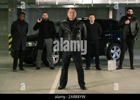 Reifer Gangster oder Strafvollmacht in schwarzer Jacke und Jeans Stockfoto