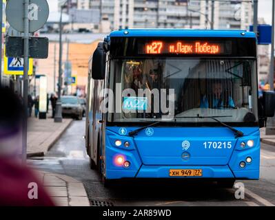 Moskau, Russland - 17. Januar 2020: Der blaue M27-Bus fährt zu einer Haltestelle des öffentlichen Verkehrs. Stadtstraße mit Bussen. Auf der LED-Anzeige der Maschine inf Stockfoto