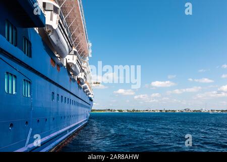 Seite eines blauen Kreuzfahrtschiffs, das im Hafen von Grand Cayman, Cayman Islands, verankert ist. Stockfoto