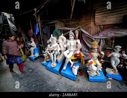 Eine Frau geht während der Vorbereitungen für das Festival an den Idolen von Devi Saraswati vorbei.Basant Panchami oder Vasant Panchami ist ein Hindu-Festival, das das kommen des Frühlings in Indien feiert. Stockfoto