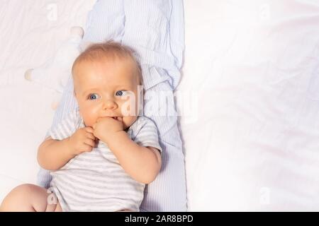 Ruhiger, fröhlicher Gesichtsaufdruck des 6 Monate alten Babys mit offener Mundnähe Stockfoto