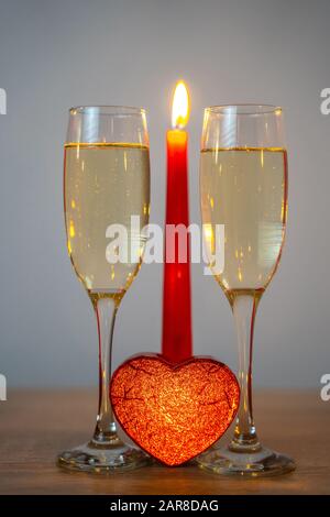 Zwei Sektgläser mit Herzkiste und brennender Kerze Stockfoto