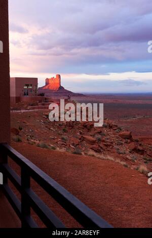 Touristen stehen im Freien auf der Point-Terrasse des Fotografen im VIEW Hotel mit Blick auf die mitten Buttes im Monument Valley Tribal Park, AZ USA Stockfoto