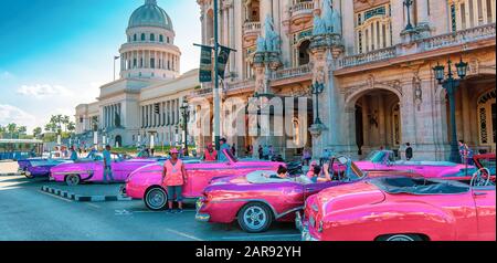 Havanna, Kuba - 16. Dezember 2019: Bunte Oldtimer warten auf Touristen in der Nähe des National Capitol Building (El Capitolio) am Paseo del Prado Str Stockfoto