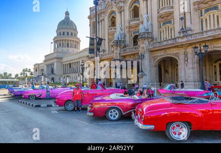 Havanna, Kuba - 16. Dezember 2019: Bunte Oldtimer warten auf Touristen in der Nähe des National Capitol Building (El Capitolio) am Paseo del Prado Str Stockfoto