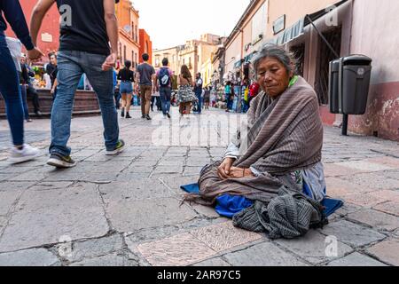 Santiago de Queretaro, Queretaro, Mexiko - 24. November 2019: Hochrangiger Bettler, der traditionelle mexikanische Kleidung trägt, lächelt für die Kamera und die Menschen wal Stockfoto