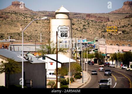 Ein großes Schild in Kingman, AZ, verkündet stolz seine Hauptstraße als Teil der Historischen U.S. Route 66. Die Route 66, die sogenannte 'Mother Road', ist wahrscheinlich die bekannteste Autobahn in den USA. Sie wurde durch das Interstate Highway Network ersetzt. Beachten Sie die Wüsten-Mesas im Hintergrund. Stockfoto