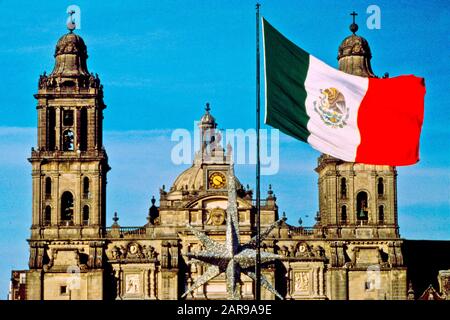 Eine mexikanische Flagge weht außerhalb der Kathedrale Metropolitana auf dem Zocalo- oder Stadtplatz von Mexiko-Stadt. Weihnachtsstern beachten. Stockfoto