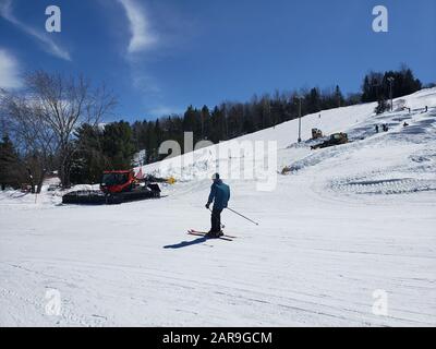 Saint-Sauveur, Kanada - 11. April 2019: Schneemaschine an einem sonnigen Frühlingstag. SOMMET Saint Sauveur ist ein Skigebiet in Quebec mit vielen Läufe, Stockfoto