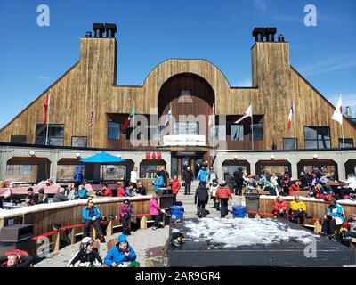 Saint-Sauveur, Kanada - 11. April 2019: Personen, die draußen im Skigebiet Sommet sitzen. SOMMET Saint Sauveur ist ein Skigebiet in Quebec mit vielen Läufe, Stockfoto