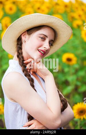 Nahaufnahme, Porträt einer jungen schönen Mädchen in einem Feld mit Sonnenblumen Stockfoto