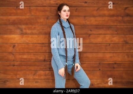 Nahaufnahme des Porträts eines jungen, schönen Teenager-Mädchens, das auf einem Holzwandhintergrund posiert Stockfoto