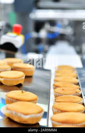 Automatische Backwaren-Muffins Produktionslinie auf Förderbandmaschinen in der Fabrik, industrielle Lebensmittelproduktion Stockfoto