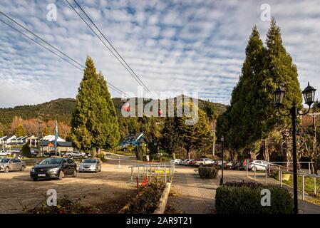 Bariloche, ARGENTINIEN, 19. JUNI 2019: Rote Seilbahn, die Passagiere auf die Spitze der verschneiten Berge im Hintergrund befördert. Stockfoto