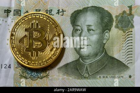 Chinesischer Renminbi mit Porträt des Vorsitzenden Mao und goldener Bitcoin. Stockfoto