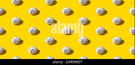 Muster aus Eiern mit minimalem Muster auf gelbem Hintergrund. Die Kulisse des Osterfestes Stockfoto