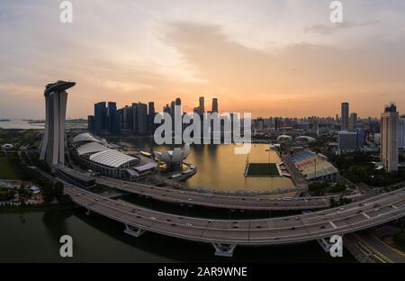 Singapur - 03. November 2019: Luftbild des Verkehrs auf einer Autobahn mit der berühmten Skyline des Geschäftsviertels von Singapur bei Sonnenuntergang im Hintergrund Stockfoto