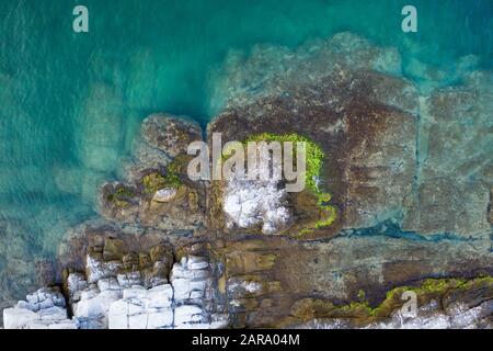 Luftbild von fliegender Drohne einer kleinen Felseninsel im offenen Meer in Griechenland Stockfoto