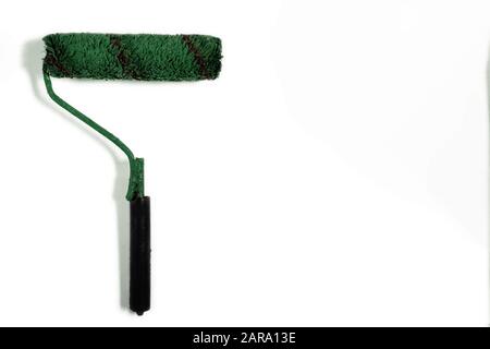 Bürstenrolle auf weißem Hintergrund mit Kopierbereich lackieren. Grün gebrauchtes Farbwerkzeug als Konzept für die Sanierung, Markenumbildung und Änderungen. Verspottete Farbe obj Stockfoto