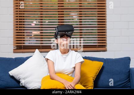Junge asiatische Frau mit Virtual reality Brillen. Headset zu Hause. zukünftige Technologie Konzept Stockfoto
