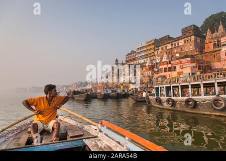 Bootsmann und morgendlicher Blick auf Holy Ghats, Ganges River, auch Ganga River, Varanasi auch Benares, Banaras, Uttar Pradesh, Indien, Südasien, Asien Stockfoto