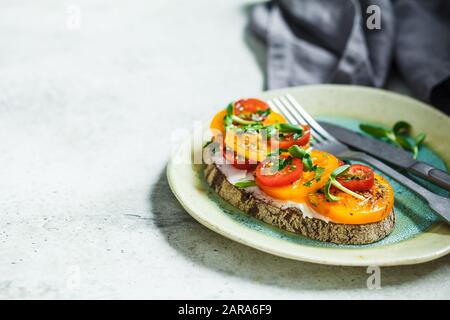 Toasten Sie mit Käse und Tomatenscheiben auf einen Teller. Vegetarisches Speisekonzept. Stockfoto