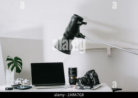 Immer noch leben, Arbeit von zu Hause aus Ausflüge mit professionellen Fotoausrüstung, Kamera, Objektiv, computer monitor, Elektronik drinnen. Stockfoto