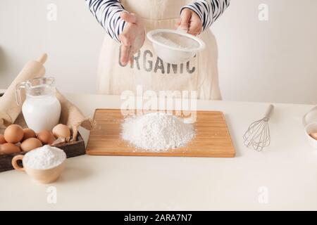 Sichtung durch ein Sieb für ein Backblech Mehl Stockfoto