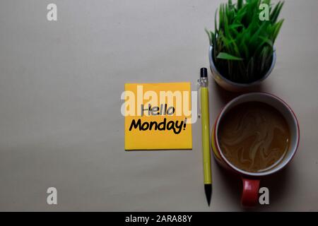 Hallo Montag! Schreiben Sie auf eine Haftnotiz, die auf dem Schreibtisch isoliert ist. Stockfoto