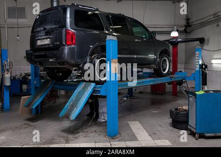Nowosibirsk, Russland - 08.01.2018: Gebrauchtes graues Auto Infiniti QX56 steht auf dem Standrad, die Konvergenz des Wagens in der Werkstatt für die Reparatur von Stockfoto