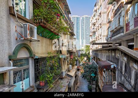 Wohnhäuser mit eingezäunten Fenstern und Balkonen im historischen Zentrum. Macau, China. Stockfoto