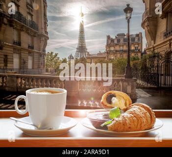 Kaffee mit Croissants gegen den berühmten Eiffelturm in Paris, Frankreich Stockfoto