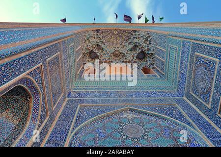 Das blaue Eingangstor der Jame-Moschee von Yazd hinter der schwarzen Flagge in Yom Ashura, Iran Stockfoto