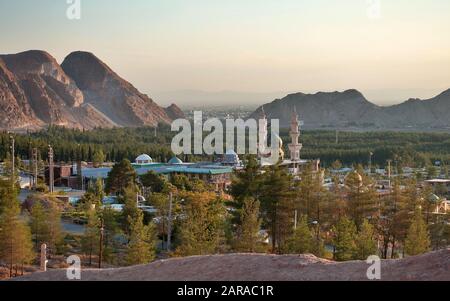 Saheb Zaman Moschee-Friedhof hinter Wüstenbergen und Wald, Kerman Iran Stockfoto